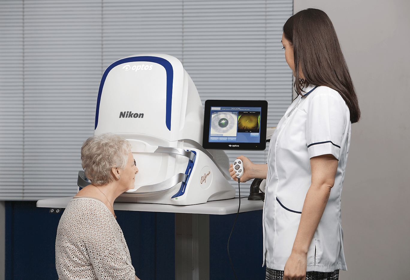 Optician showing elderly patient the scans of her eyes