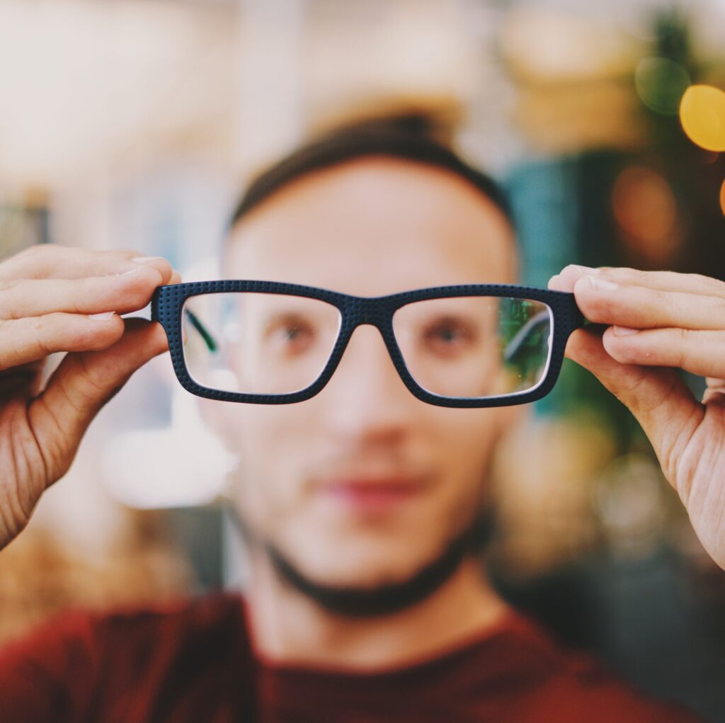 Out of focus man behind in focus glasses
