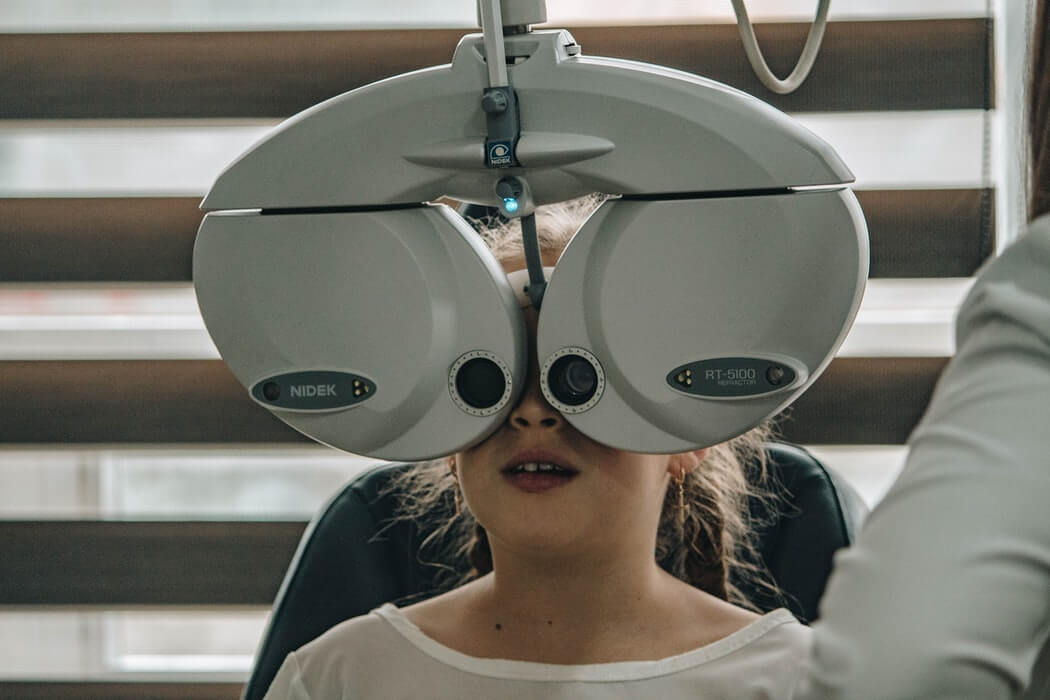 A young child having her eyes tested by an optician.