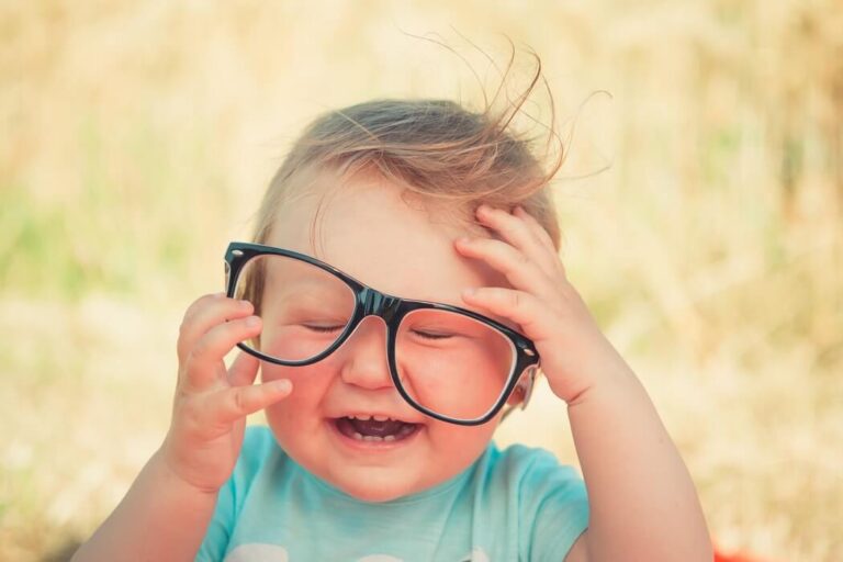 Toddler wearing adult glasses that are too big for him