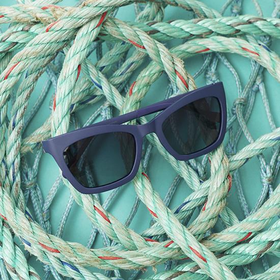 A pair of blue sunglasses on a bundle of ropes