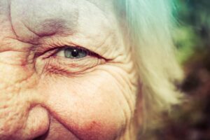 Half face image of an elderly person's blue eye