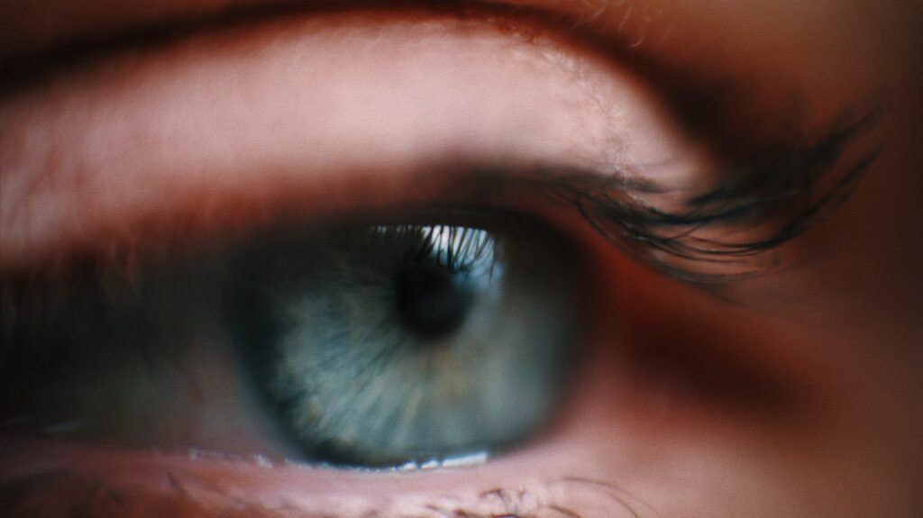 Close up side view image of a blue eye framed with lashes