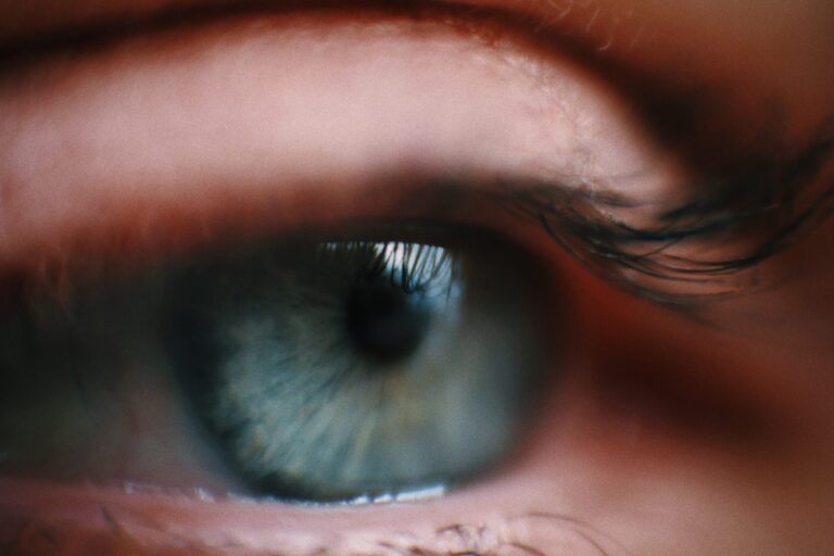 Close up side view image of a blue eye framed with lashes