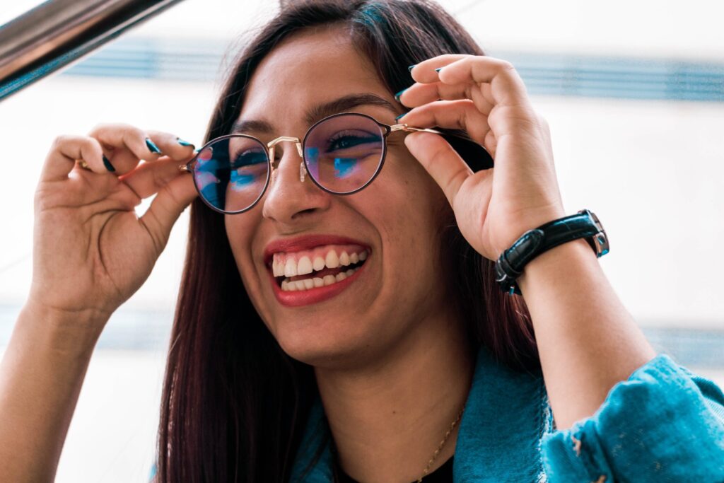 Brunette woman laughing as she tries out new glasses