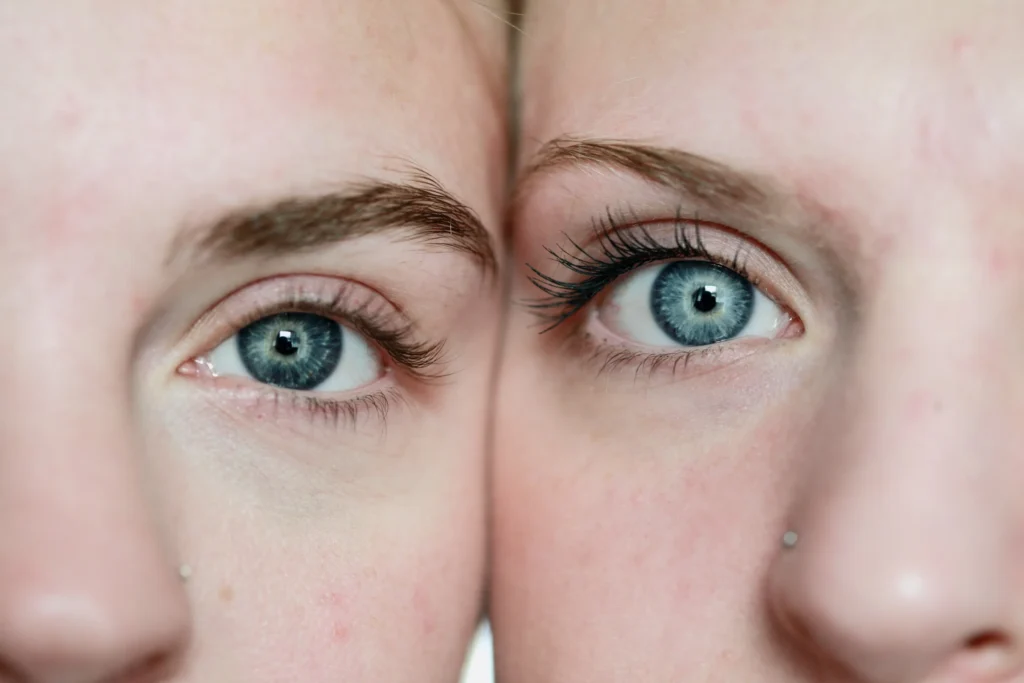 Close up of two women with their heads side by side, looking into the camera with blue eyes