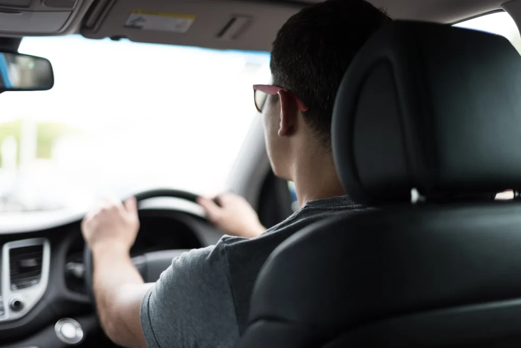 Man driving a car while wearing glasses